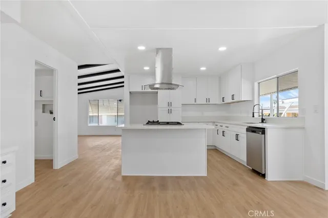 an empty room with wooden floor fireplace and windows