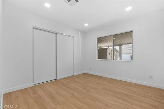 a view of a room with wooden floor and a ceiling fan