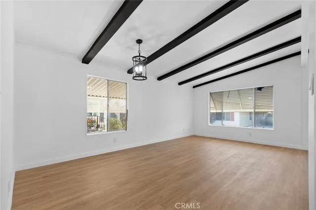 a large kitchen with stainless steel appliances granite countertop a stove top oven a sink and white cabinets