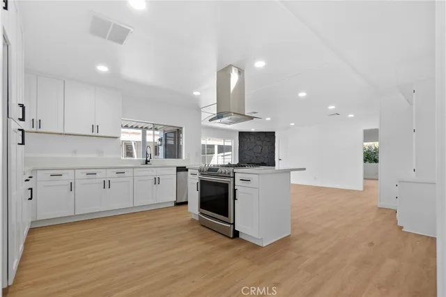 a kitchen with granite countertop white cabinets and stainless steel appliances