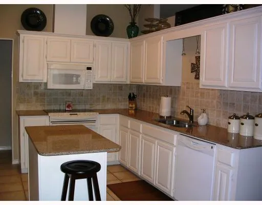 a kitchen with stainless steel appliances a stove a sink a refrigerator and cabinets