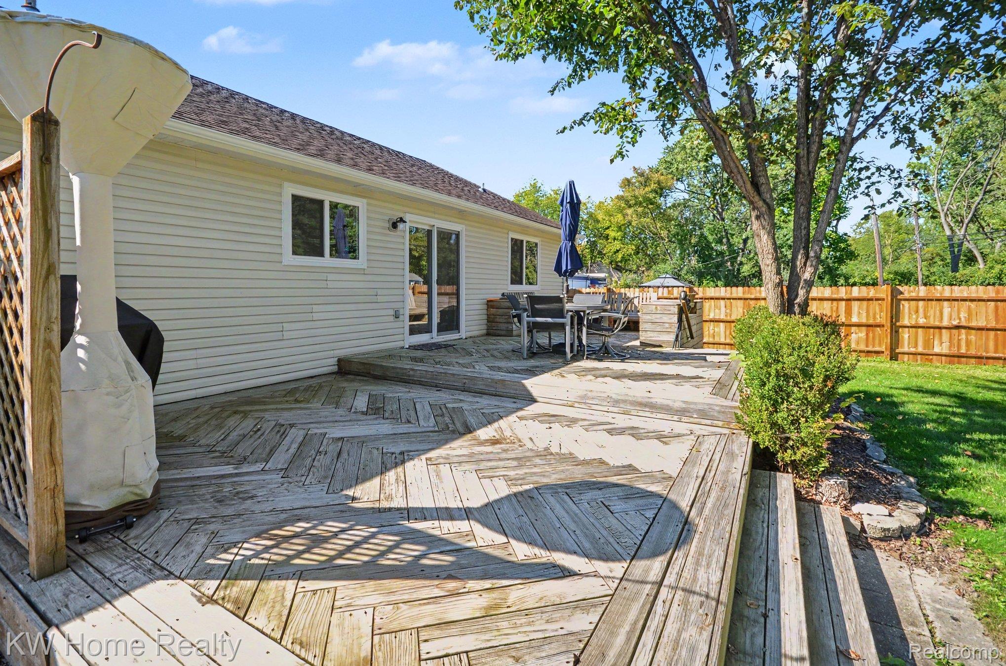 2383 East Maple Road Troy, MI 48083 - Photo 19 of 25 Expansive wood deck with a herringbone pattern, exterior siding, and sliding glass door access