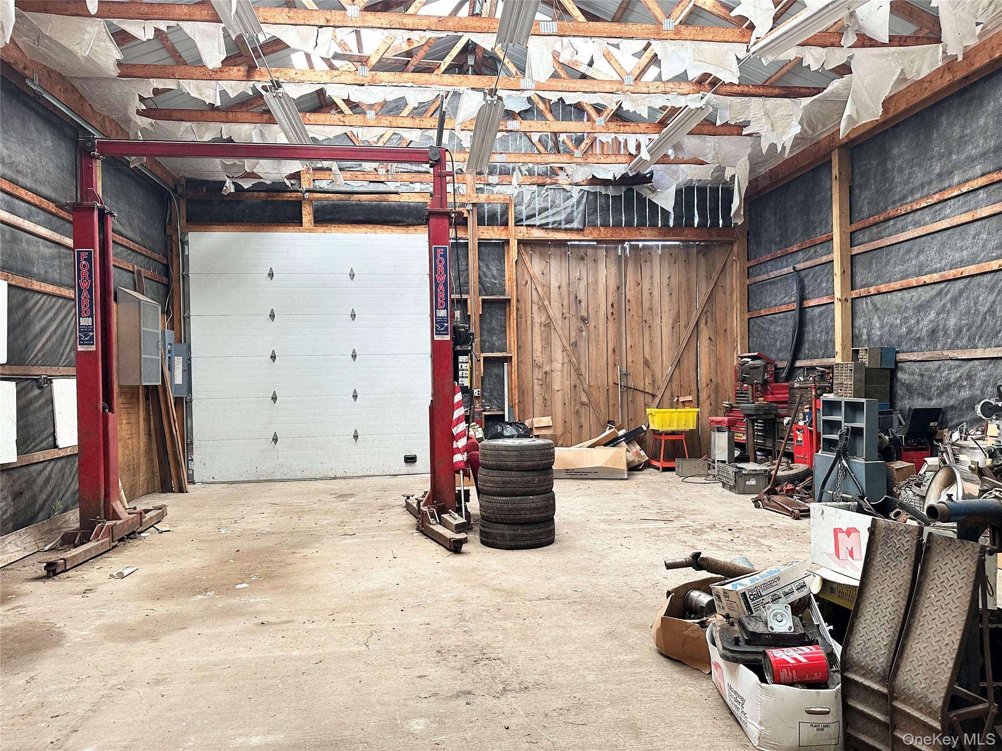 818 Methol Road Roscoe, NY 12776 - Photo 39 of 39 Additional oversized garage interior featuring vehicle lift, soaring ceilings, and substantial open-span workspace ideal for collectors, trades, or recreational storage.