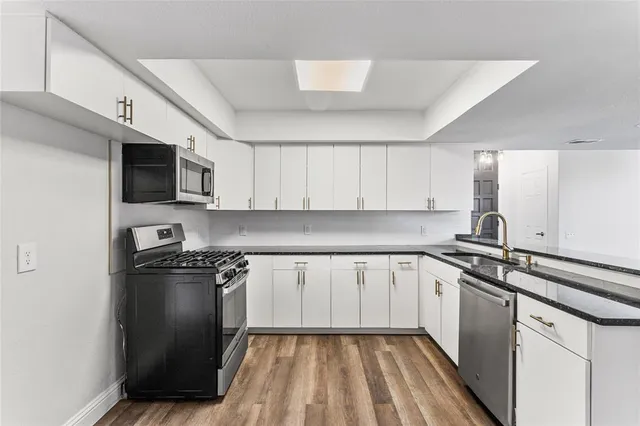 a kitchen with a sink stove and microwave