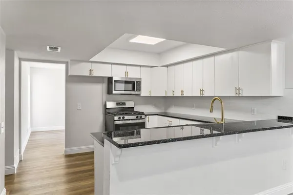 a kitchen with stainless steel appliances granite countertop a sink stove and refrigerator