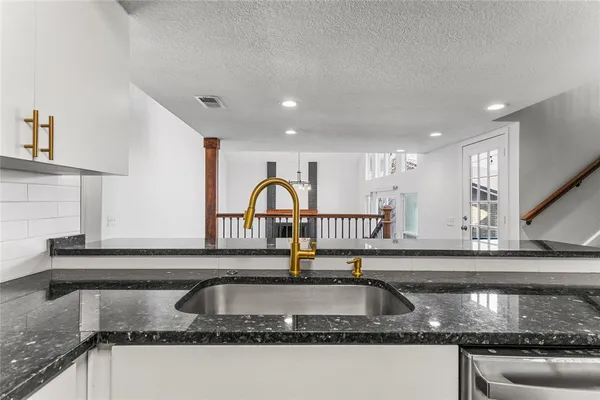 a kitchen with granite countertop a sink and a window