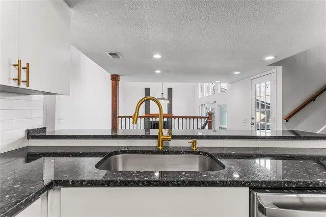 a kitchen with granite countertop a sink and a window