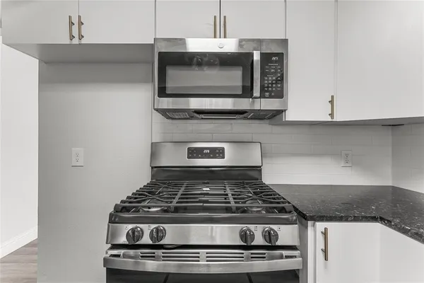 a stove top oven sitting inside of a kitchen