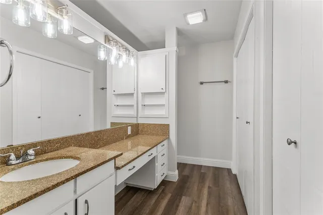 a bathroom with a granite countertop sink and a mirror