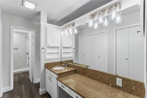 a bathroom with a granite countertop sink and a mirror