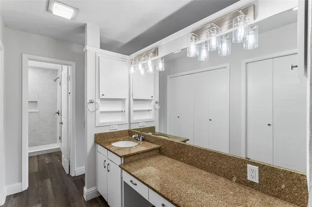 a bathroom with a granite countertop sink and a mirror