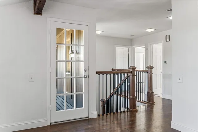 a view of a hallway with wooden floor and door
