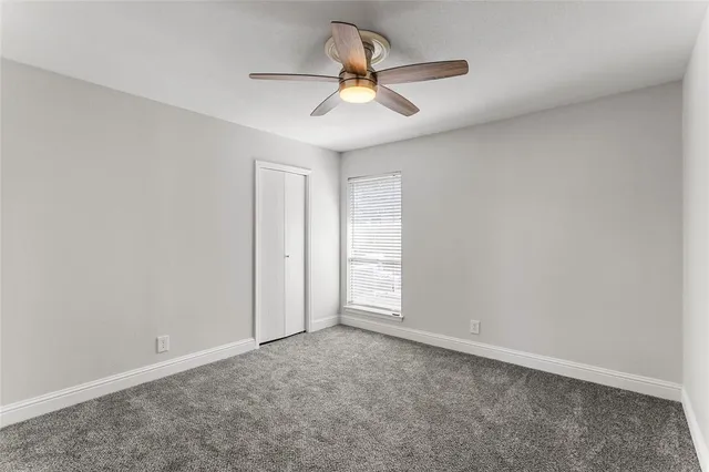 an empty room with closet and windows