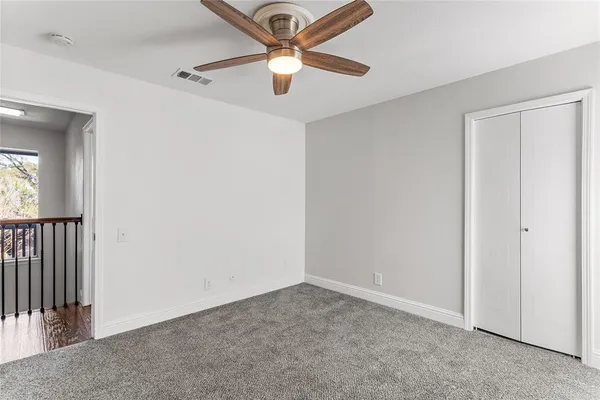 an empty room with a ceiling fan and a window