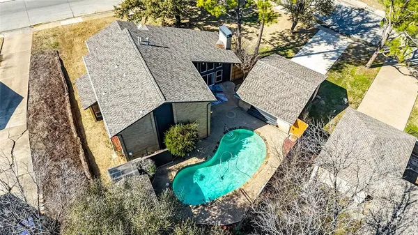 an aerial view of a house with a yard and mountain view in back