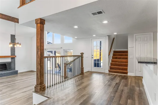 a view of a hallway with stairs and wooden floor