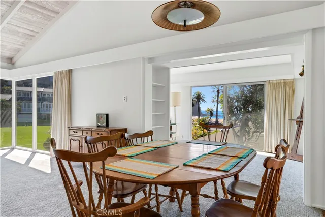 a dining room with furniture a rug and a floor to ceiling window