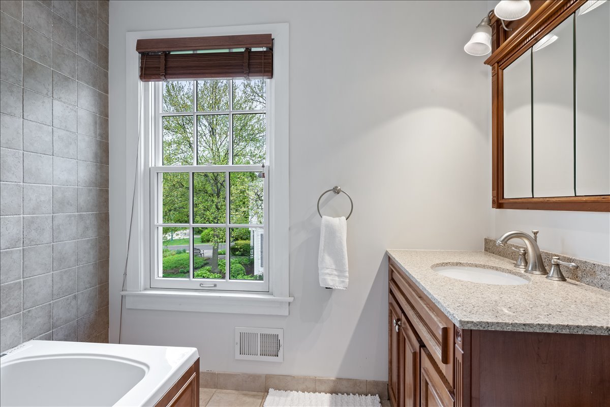 910 Chippewa Lane Wilmette, IL 60091 - Photo 26 of 38 a bathroom with a granite countertop sink and a bathtub