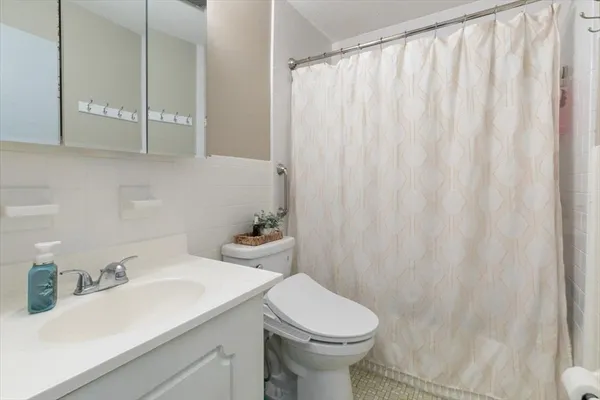 a bathroom with a sink a toilet and shower curtain