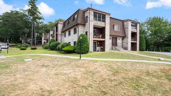 a front view of a house with garden and trees