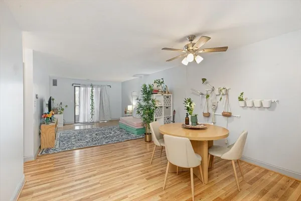 a dining room with furniture a chandelier and wooden floor