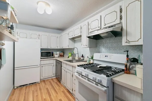 a kitchen with stainless steel appliances granite countertop a stove a sink dishwasher and a refrigerator