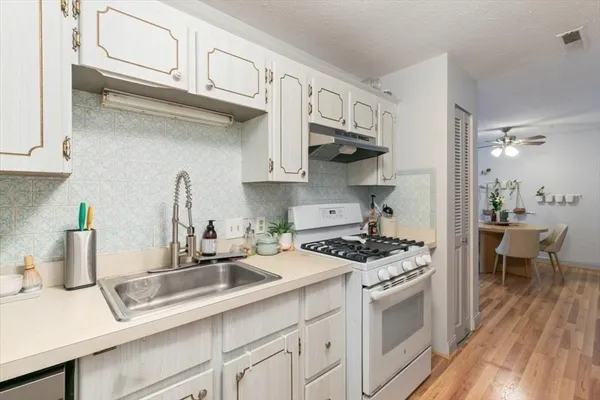 a kitchen with stainless steel appliances a sink a stove and cabinets
