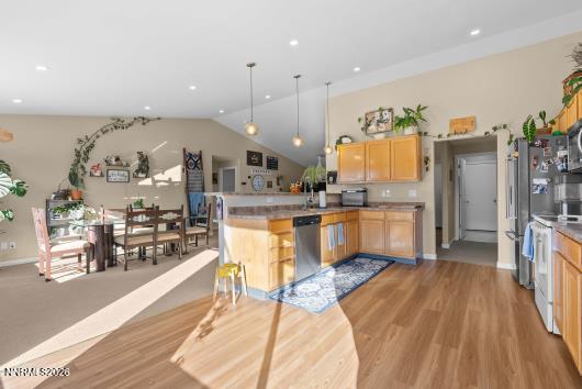 552 Spur Court Fernley, NV 89408 - Photo 17 of 46 a kitchen with stainless steel appliances kitchen island granite countertop a refrigerator a sink a stove and oven with wooden floor