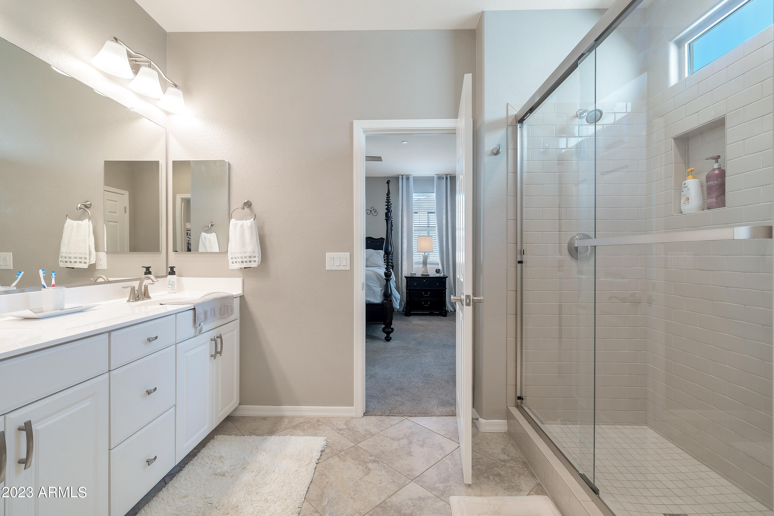 21218 West Granada Road Buckeye, AZ 85396 - Photo 19 of 34 a spacious bathroom with a double vanity sink shower and mirror