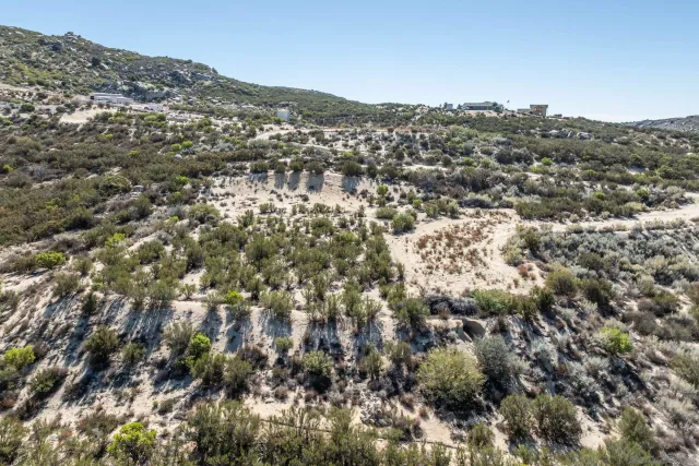 an aerial view of residential houses with outdoor space and trees