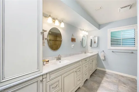 a spacious bathroom with a double vanity sink and a mirror
