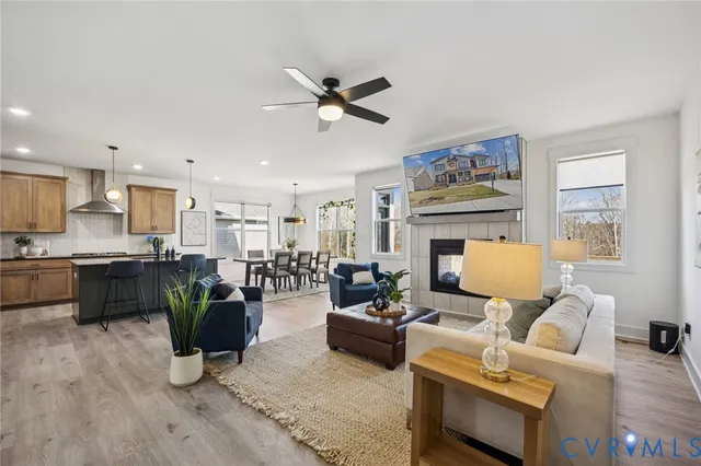 a kitchen with stainless steel appliances granite countertop a stove a refrigerator a sink a center island a counter space and wooden floor