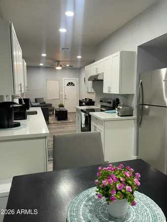 a kitchen with a sink a refrigerator and cabinets