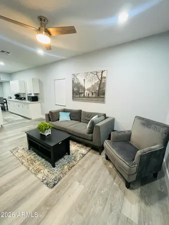 a living room with furniture and a view of kitchen