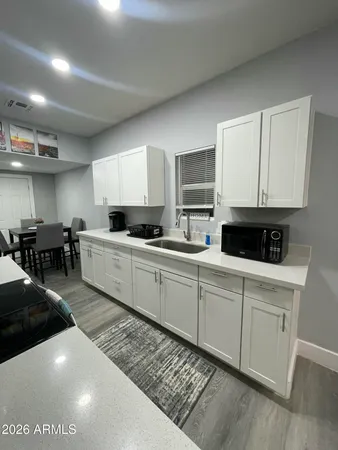a kitchen with stainless steel appliances a stove a sink a microwave a center island and cabinets