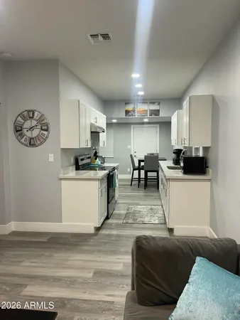 a view of kitchen with refrigerator stove and wooden floor