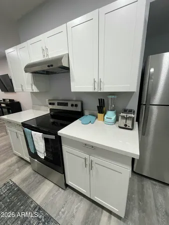 a kitchen with a sink a refrigerator and cabinets
