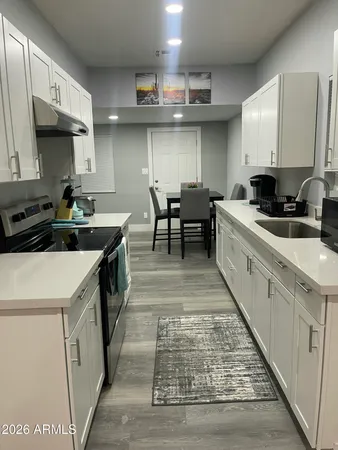 a kitchen with stainless steel appliances a sink stove and cabinets