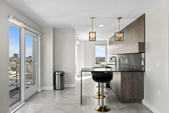 a view of kitchen with stainless steel appliances kitchen island dining table and chairs