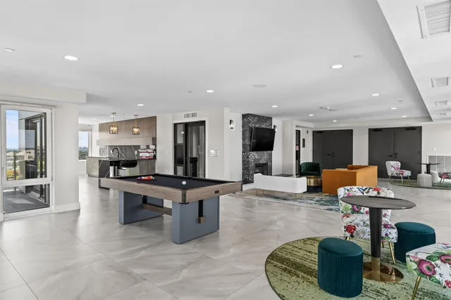 a living room with furniture a table and kitchen view