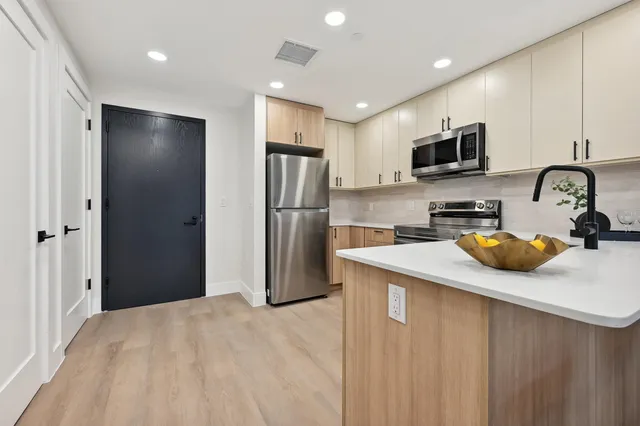 a kitchen with stainless steel appliances a refrigerator sink and microwave