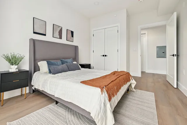 a bedroom with bed and wooden floor