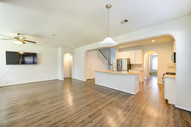 a view of a living room and kitchen with a wooden floor