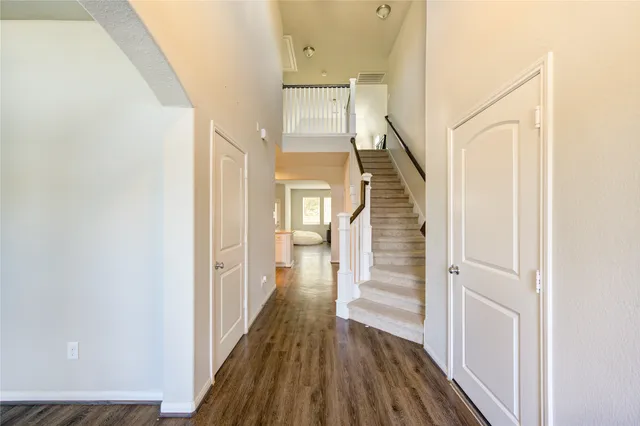 a view of a hallway with wooden floor and staircase