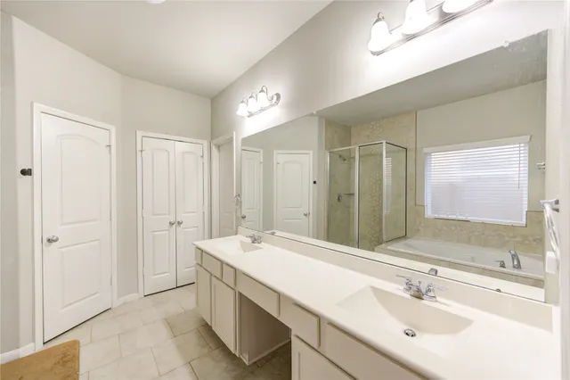 a spacious bathroom with a shower sink and mirror