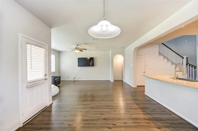a view of an empty room with window and wooden floor