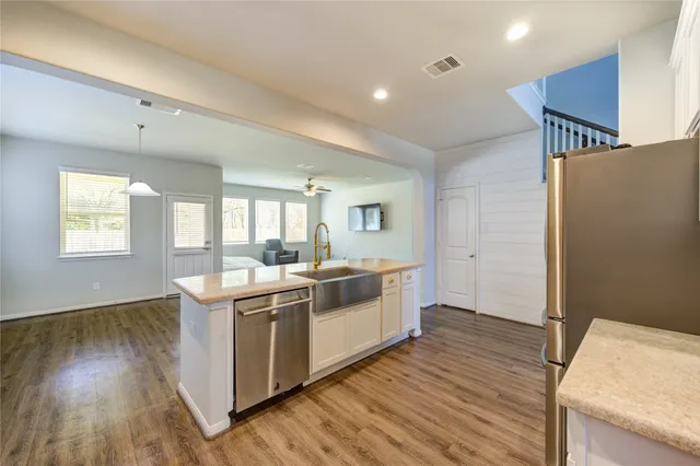 a kitchen with a stove and wooden floor