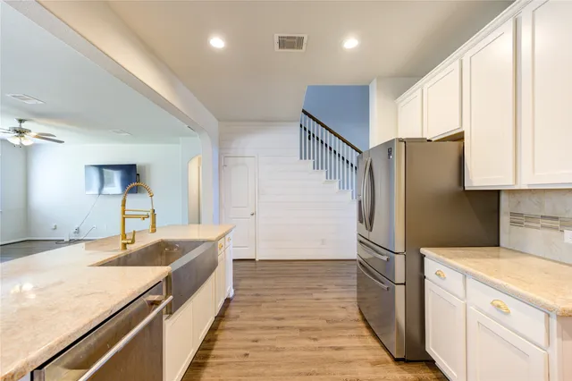 a kitchen with granite countertop a refrigerator and a sink