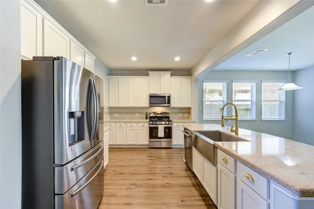 a kitchen with stainless steel appliances granite countertop a refrigerator stove and sink