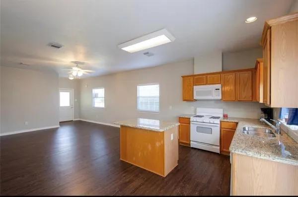 a kitchen with stainless steel appliances granite countertop wooden cabinets a stove a sink and a window